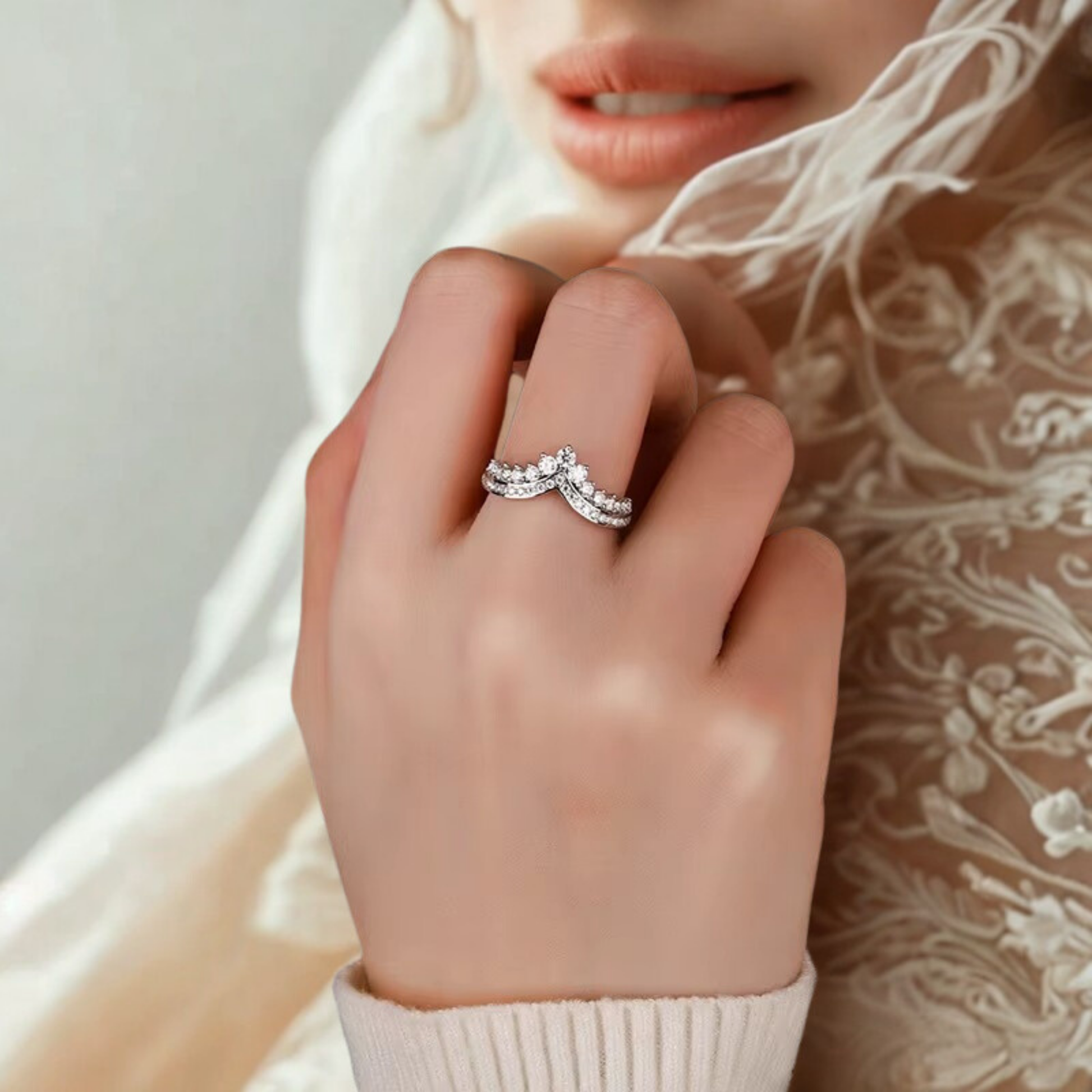 Anello in Moissanite con design a tiara indossato su una mano femminile, sfondo beige elegante